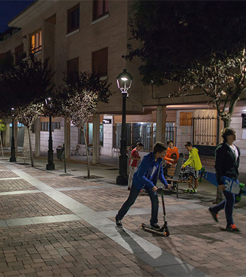 Folk går rundt i Palencias gader om aftenen og nyder Philips-belysningen.