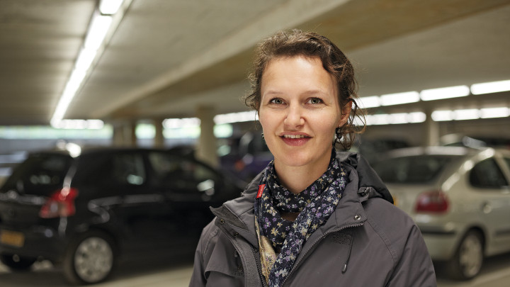  Kvinder, der smiler foran bilerne i Eiteren-parkeringshuset, som er belyst af Philips Lighting 