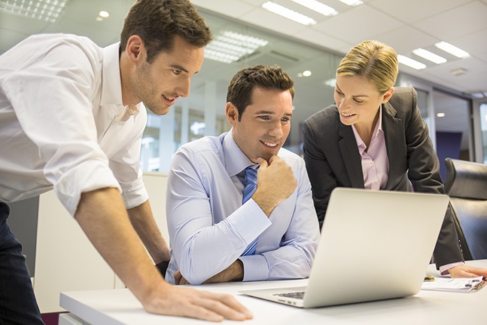 Business people are talking in front of an open laptop