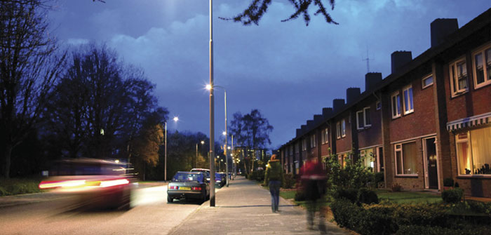 Biler i en gade effektivt belyst af hvidt lys fra Philips