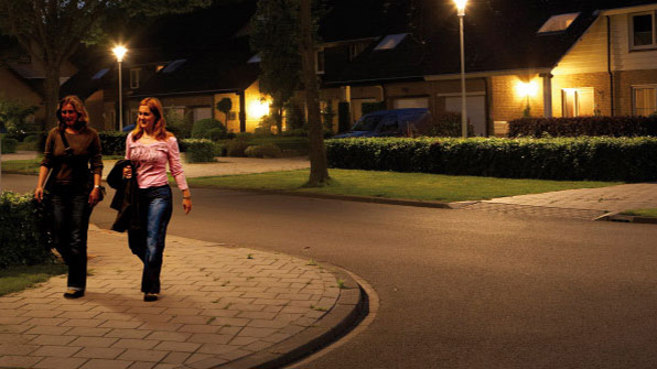 To kvinder spadserer i en gade, der er oplyst med hvidt lys fra Philips