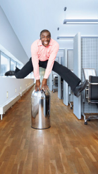 En mand hopper i gangen på et kontor oplyst med dynamisk belysning fra Philips