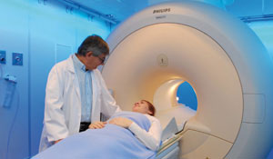 Læge klargør en patient til en MR-scanning.