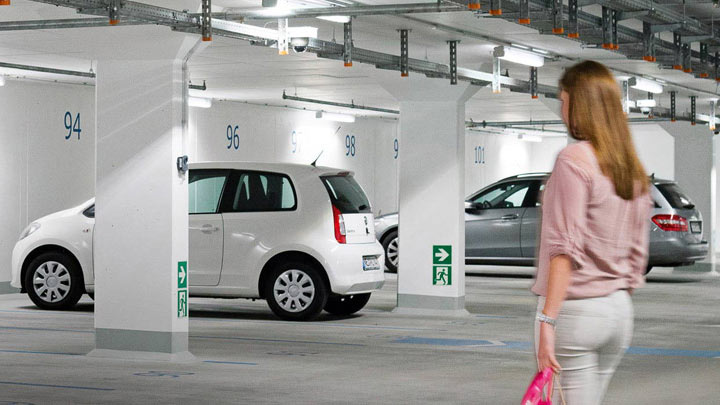 Kvinde på vej til sin bil i en godt oplyst parkeringskælder 