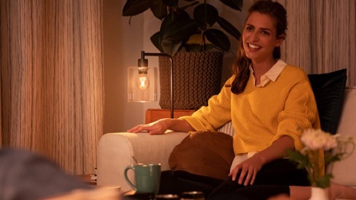 Kvinde nyder dæmpet lys på sofaen derhjemme