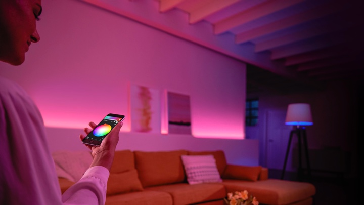 Person kontroller farvet lys i en stue