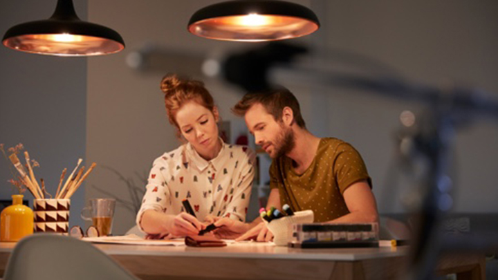 To mennesker laver en belysningsplan ved et godt oplyst skrivebord